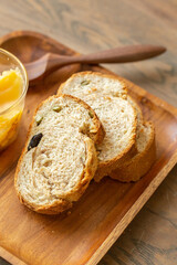 Sliced Multi-Grain Bread with Seeds and Dried Fruit on Wooden Tray, bread with raisins and honey on wooden plate, stock photo