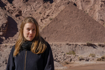 Young woman posing in front of pyramid-shaped desert hill