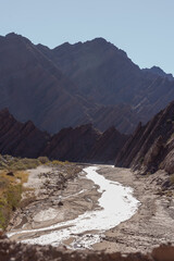 Winding shallow river in folded mountain desert landscape