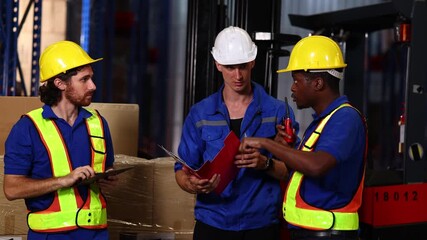 Three Warehouse workers moving cardboard boxes with hand pallet truck in distribution warehouse center. E-Commerce Goods at Logistics Warehouse factory. warehouse with shelves, pallets and boxes - Powered by Adobe