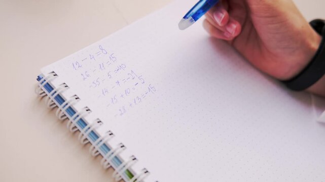 student's hands writing math problems in notebook on table closeup, academic focus, Education and learning, spiral college block, student writing supplies, back to school, Homework and problem-solving - Powered by Adobe