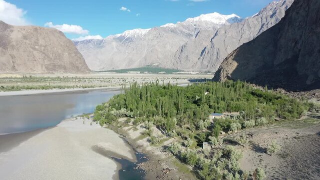 Aerial drone view of green valley with river flowing beside mountains