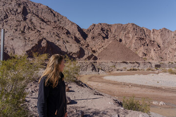 Young woman posing in front of pyramid-shaped desert hill