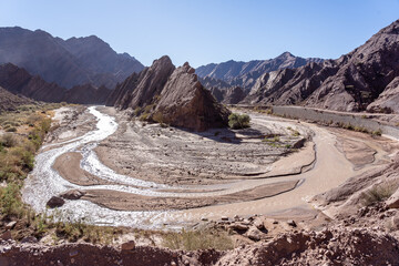 Winding shallow river in folded mountain desert landscape