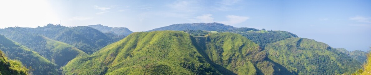 Naklejka premium Expansive panorama of Vagamon hill station, Kerala, featuring verdant valleys and dramatic mountain ranges in daylight, perfect for beauty and adventure concepts
