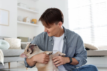 Man with his cute French bulldog at home