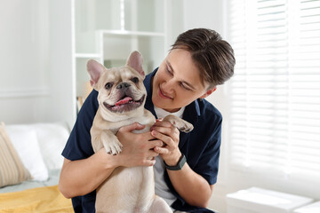 Man with his cute French bulldog at home