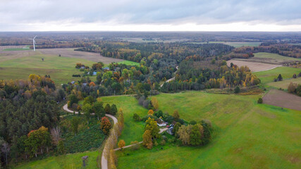 Aerial View of the Latvian Countryside in Autumn with a Wind Turbine on the Horizon