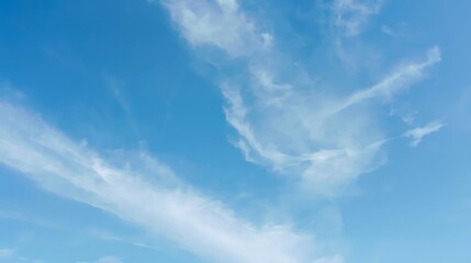 Bright Blue Sky with Wispy Clouds Drifting Across the Horizon