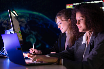 Colleagues discuss stock market trends in a modern office setting during evening hours