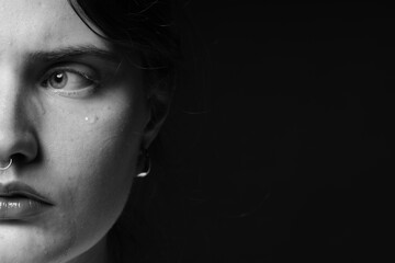 Sad woman crying on dark background, closeup. Black and white effect