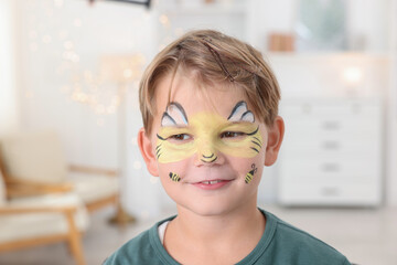 Cute boy with bee painting on his face at home
