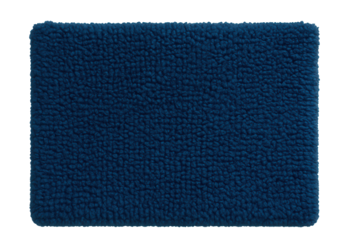 A deep blue chenille bath mat adds a vibrant touch to a minimalist bathroom.