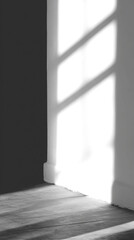Obraz premium Dramatic grayscale interior shot with window frame casting sharp shadow on floor and wall