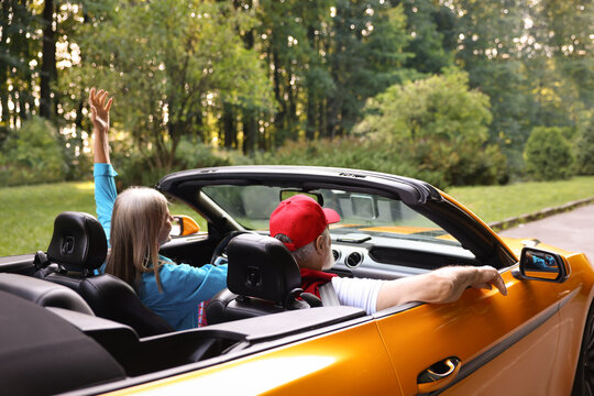 Stylish senior couple enjoying cabriolet ride outdoors