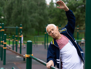 Mature man practice on the sports ground equipment in park