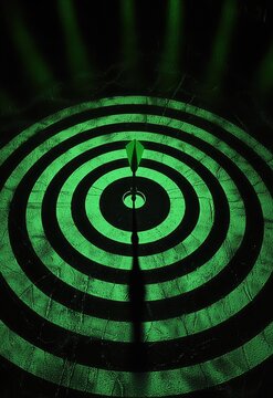 A dartboard scene with a green dart locked into the bullseye, the target&acirc;&euro;&trade;s rings glowing to emphasize the shot&acirc;&euro;&trade;s accuracy. Stock