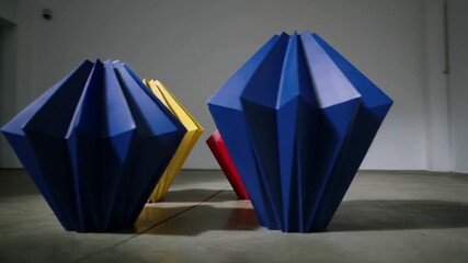 Camera initiating panning right across minimalist gallery, revealing red yellow blue sculptures - Powered by Adobe