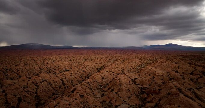 Storm clouds brewing over dramatic desert terrain with lightning strike, aerial