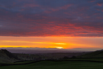 Sun setting over the Lake District Mountains looking over the eden valley. Cumbria, England, UK.