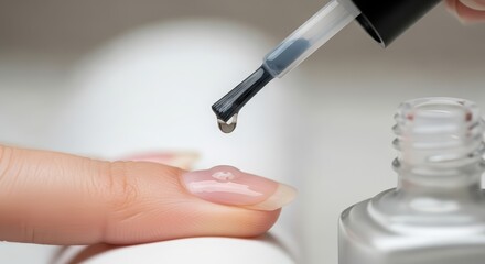 Clear top coat nail polish drop on woman finger during manicure procedure. Professional beauty treatment at nail salon concept.