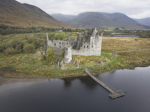 Aerial view of the rugged, ancient stone castle stands proudly against the moody gray sky, a testament to history reflected in the still, dark waters, Edimburg, Scotland.