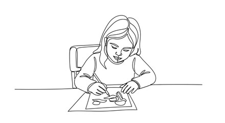 Focused young girl engrossed in drawing a picture at a table