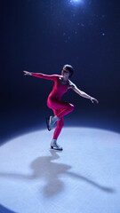 Female figure skater in pink outfit gliding gracefully in balanced one-leg spin on ice. Concept of inner control, elegant mindfulness, body harmony, and emotional focus in dynamic stillness.
