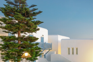 artistic architectural background with white houses and blue shutters under clear sky. minimalist architecture design. soft pastel colors. whitewashed buildings