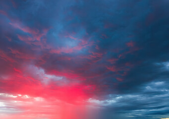 Dramatic sky with storm clouds illuminated by red sunset or sunrise. Vivid colorful cloudscape for nature banner or weather background. Bright sunset or sunrise light.