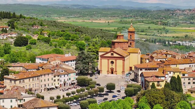 Aerial view of the historic Sinalunga, showcasing the church contrasting with the verdant landscape, a picturesque scene, Sinalunga, Tuscany, Italy.