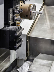 CNC machine in operation with metal shavings during precision machining process in a workshop