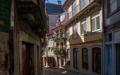 A quiet morning on a narrow cobblestone street in Porto, flanked by colorful traditional houses...