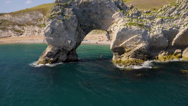 Aerial view of Durdle Door, an iconic limestone arch standing proudly against the deep blue sea, contrasting with the white cliffs, Lulworth, England, United Kingdom.