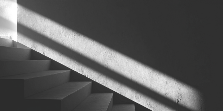 Stairway bathed in a stripe of sunlight on a textured wall, stark contrast - Powered by Adobe