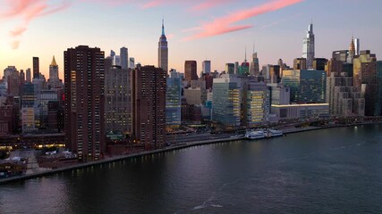 Aerial view of the Empire State Building and other city skyscrapers, a stunning urban skyline contrasting with the dark water, New York, New York, United States. - Powered by Adobe