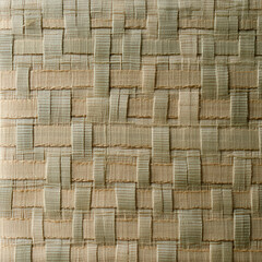 A woven fabric with a pattern of squares and triangles. The fabric is light brown and has a woven texture