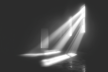 Stark interior with light streaming through shapes, casting shadows in monochrome