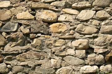 Exploring an ancient stone wall constructed with varying rock types in a rustic outdoor setting