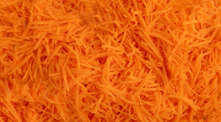Fresh Finely Grated Carrots Textured Background, Raw Carrot Pieces Closeup Pattern