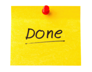 A bright yellow sticky note with the word "DONE" written in bold black letters, attached by a red pushpin.