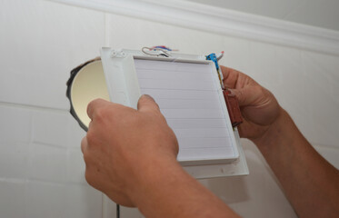 Installing electric exhaust fan in bathroom wall ventilation system