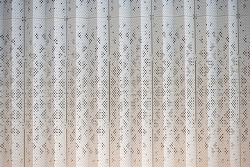 Perforated metal facade with vertical striped pattern. Architectural texture for industrial, modern...