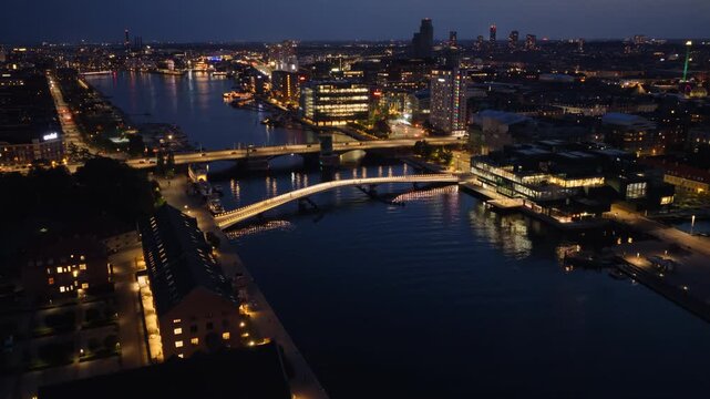 Aerial drone view of Langebro Bridge connecting Christianshavn to the city center, with Copenhagen's illuminated skyline beyond