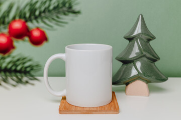 Mockup mug on bamboo cup coaster with christmas tree on green background. Ceramic mug with copy space for winter design, christmas and new year gift, print