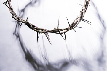 Crown of thorns casting a distinct shadow a white background, creating a symbolic easter image of suffering, sacrifice, and remembrance Copy good text friday for space