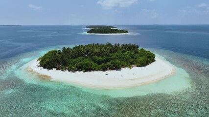 Aerial view of lush green islands surrounded by turquoise and deep blue waters, creating a stunning contrast, Kendhoo, Baa Atoll, Maldives.