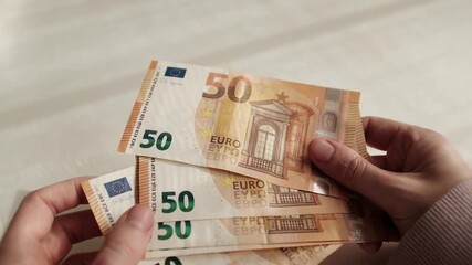 Closeup of woman's hands counting Euro cash banknotes. Caucasian woman calculates his income, salary, profit. Making money, success, wealth concept. Horizontal video. - Powered by Adobe