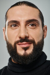 Fototapeta premium Handsome middle eastern man with a beard showcasing a stylish studio look