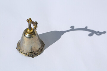 silberne Glocke auf weißem Hintergrund, Schatten